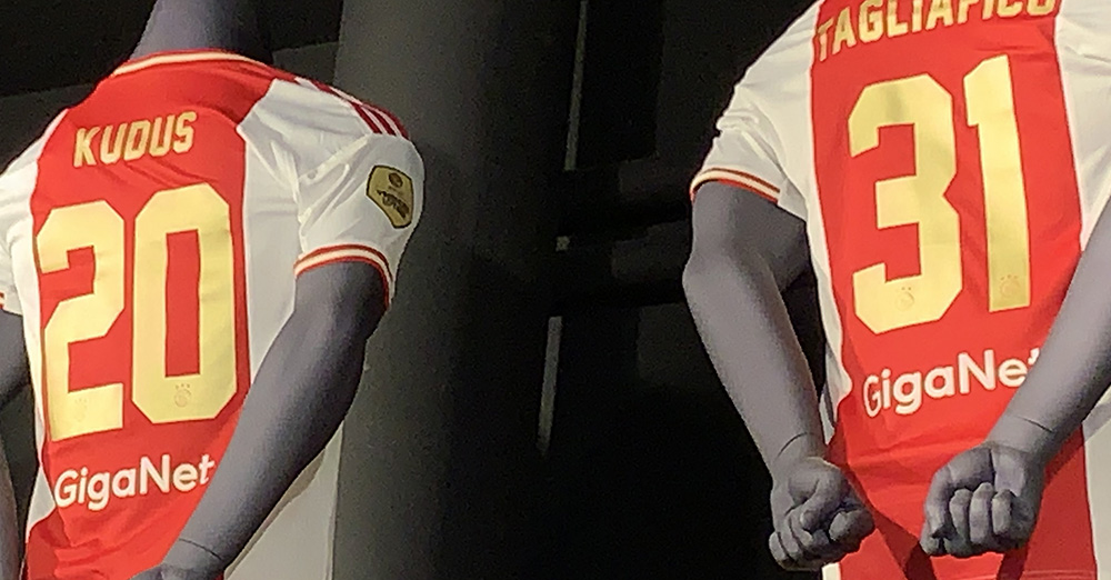 Afname Salie Reisbureau GigaNet op Ajaxshirt bij bedrukken gouden eredivisiebadge