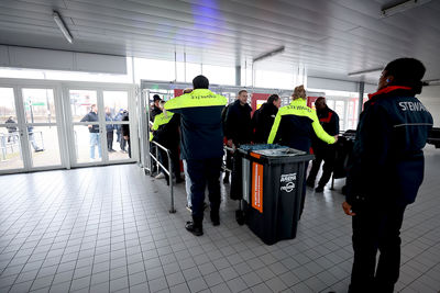 Poortjes door en richting de klaarstaande bussen. © De Brouwer