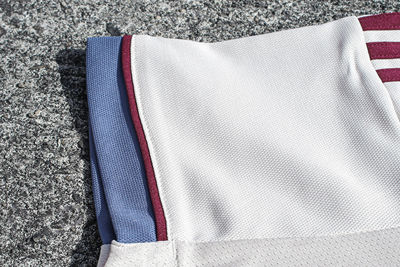 De details op de mouwen zijn marineblauw en bordeauxrood. © Ajax Life